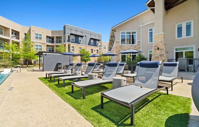 A sunny day at a resort with a pool and lounge chairs.