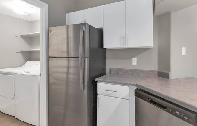 A kitchen with a refrigerator, dishwasher, and oven.