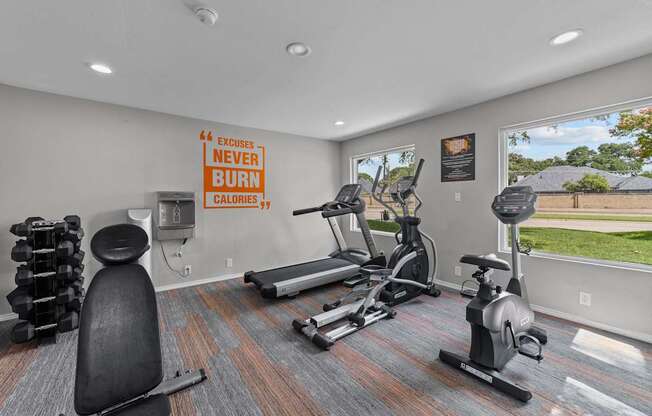 A gym room with a sign that says "Excuses Never Burn Calories".