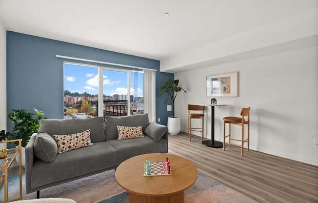 A living room with a grey couch and a wooden coffee table.
