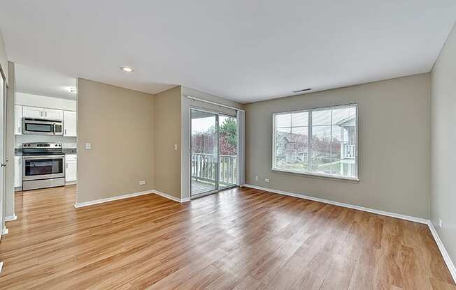 an empty living room with wood flooring and a sliding glass door