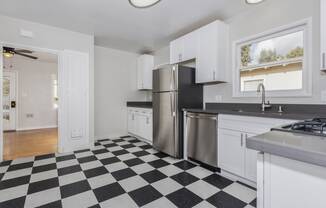 a kitchen with a checkered floor and a stainless steel refrigerator