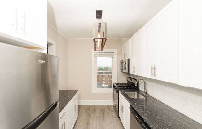 a kitchen with granite counter tops and stainless steel appliances at The Packard, West Hartford, Connecticut