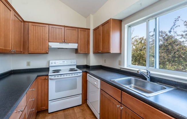 a kitchen with black countertops and white appliances