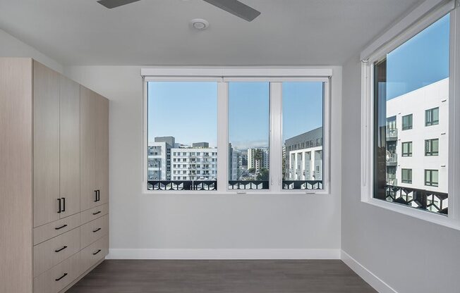 a bedroom with a large window and a dresser
