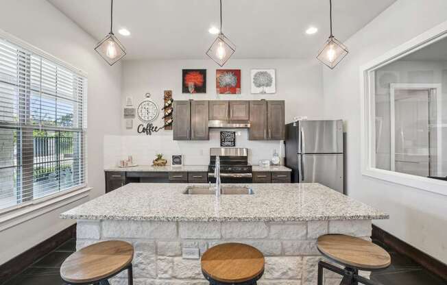 A kitchen with a marble countertop and wooden stools.