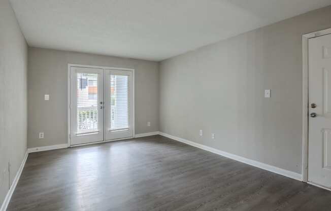 an empty living room with white walls and wood floors