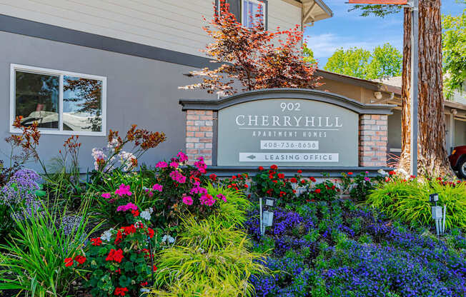 A sign for Cherryhill Apartment Homes with a phone number and leasing office direction.