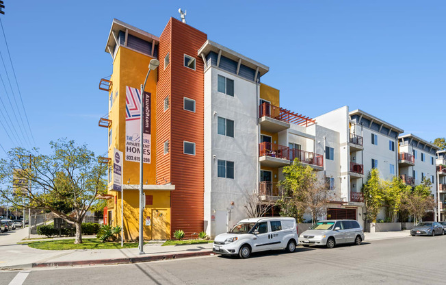 a new apartment building with cars parked in front of it