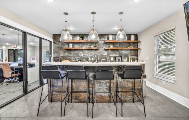 a kitchen with a bar and chairs in front of a window at Sunset Ridge, San Antonio, Texas