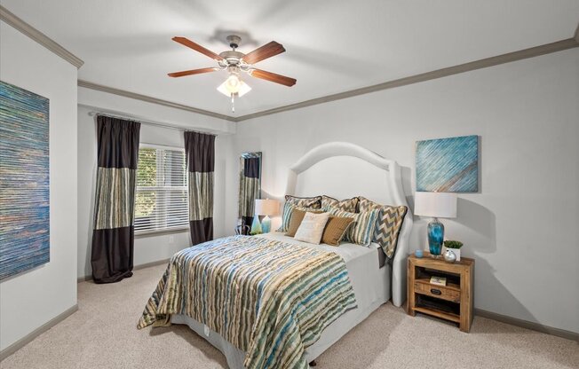 a bedroom with a bed and a ceiling fan