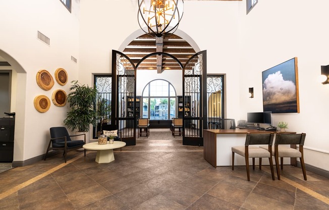A large room with a chandelier and a long table with chairs.