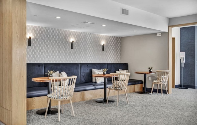 a lounge area with tables and chairs and a blue couch