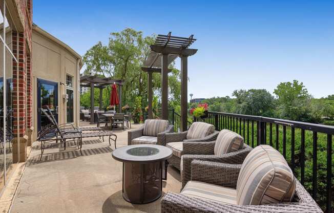 a patio with wicker furniture and a table on a balcony