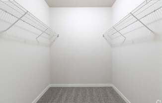 a room with white walls and two wire shelves on the wall