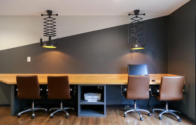 a desk with a computer and a chair in a room