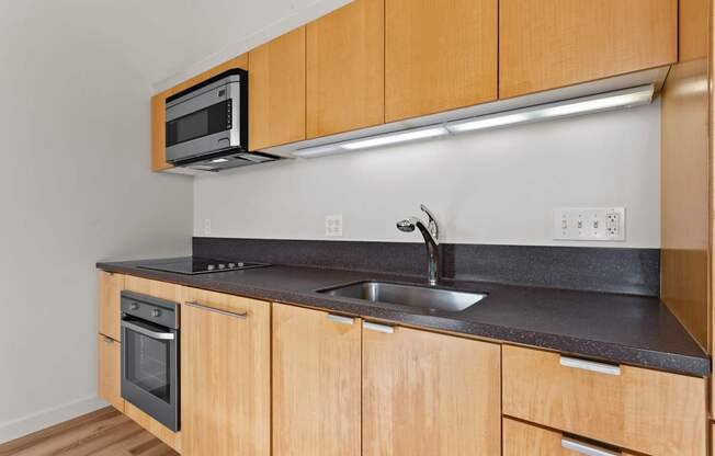 A kitchen with wooden cabinets and a black countertop.