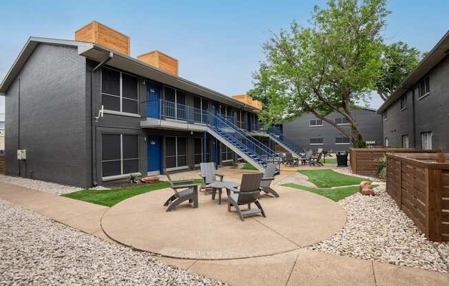 outdoor patio between apartment buildings at Stadium 700 with lawn chairs and table.