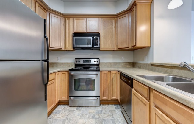 a kitchen with wooden cabinets and stainless steel appliances