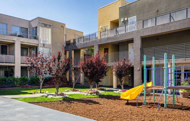 an outdoor playground in front of an apartment building