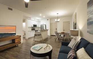 a living room and kitchen with a couch and a table