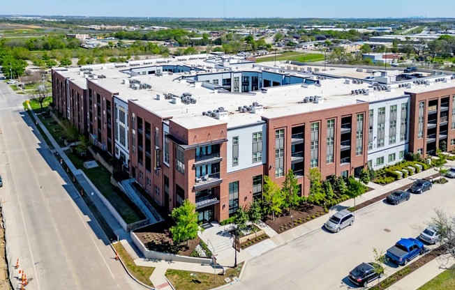 an aerial view of a building with cars parked in front of it