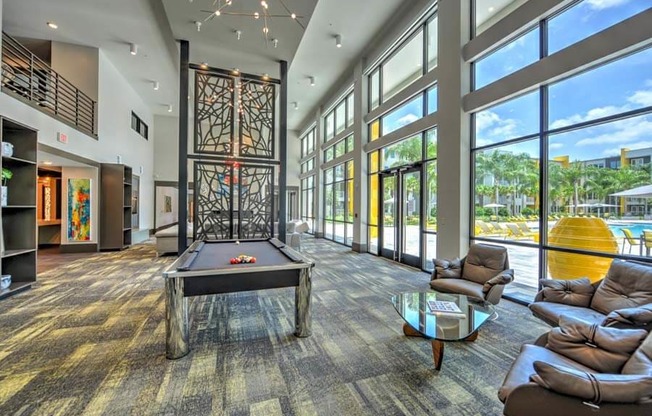 a large room with a pool table and a lot of windows  at Fusion, Jacksonville, FL, 32256