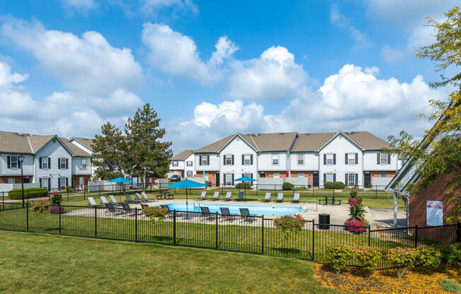 the view of a swimming pool with apartments in the background