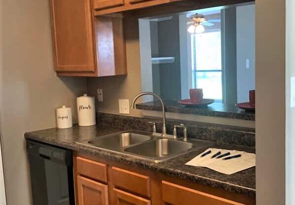 A kitchen with wooden cabinets and a granite countertop.