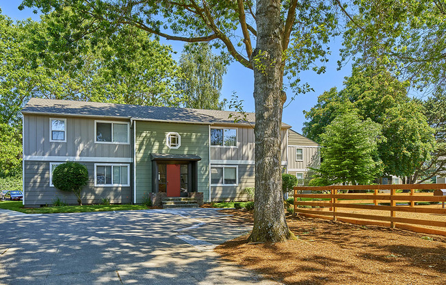 Exterior view of community. Shows a large tree along with wooded area.at Woodhaven, Everett