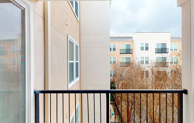 A balcony with a black railing and a view of a building.