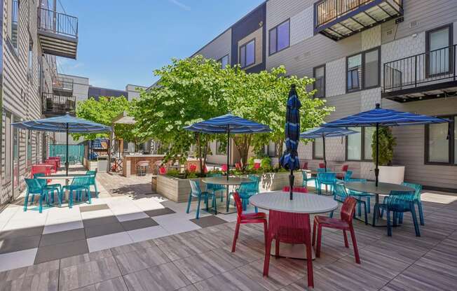 a patio with tables and chairs and umbrellas