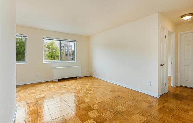 vacant living area with hardwood flooring and large windows at chillum place apartments in lamond riggs washington dc