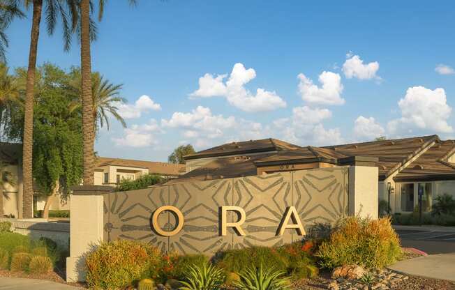 a sign that says in front of a building with palm trees