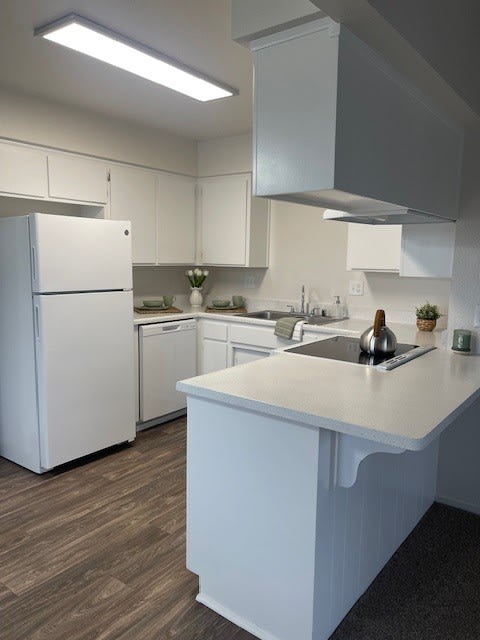 a white kitchen with a counter and a refrigerator