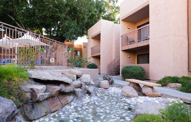 A small waterfall in a courtyard surrounded by buildings.