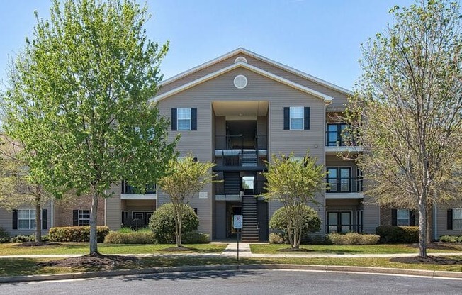 a large apartment building with trees in front of it