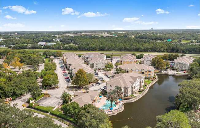 A bird's eye view of a residential complex with a lake in the foreground.