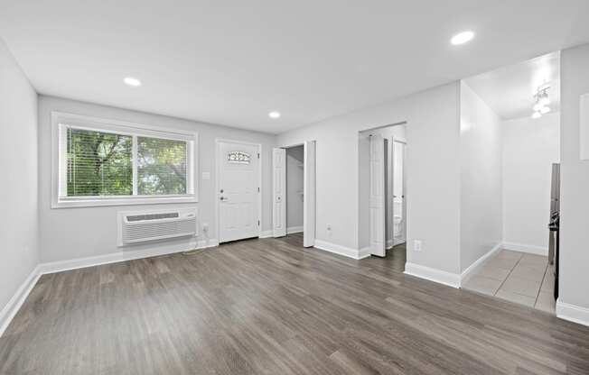 an empty living room with white walls and a window