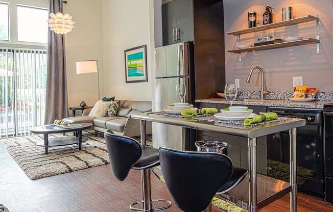 a kitchen with an island and two chairs in front of it at Link Apartments® Canvas, Georgia, 30312