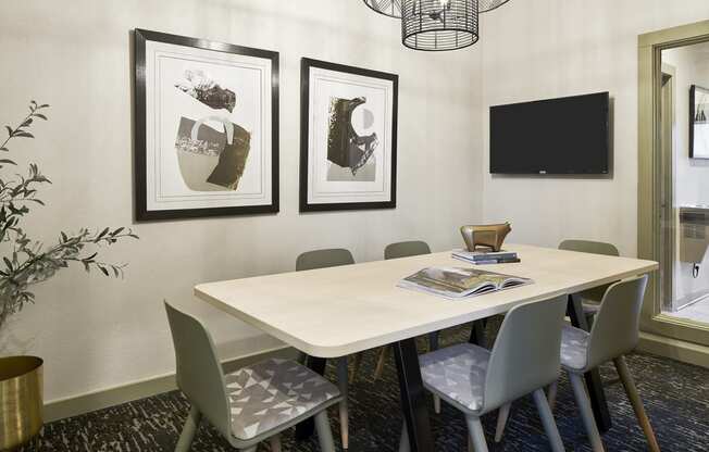 a conference room with a table and chairs and pictures on the wall