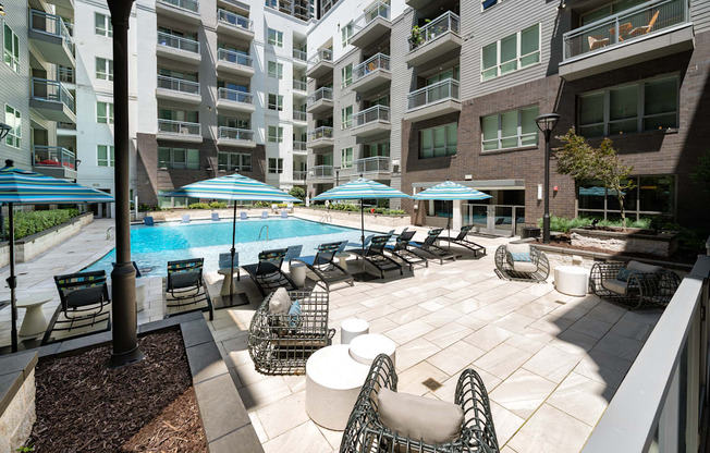 A large outdoor patio with a pool and chairs.
