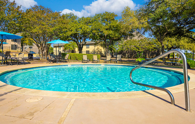 a resort style pool with a slide and chairs and umbrellas