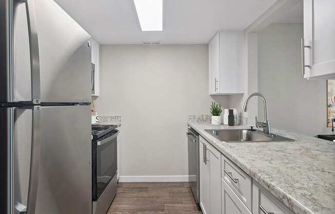 Model Kitchen with White Cabinets and Wood-Style Flooring at Overlook Point Apartments in Salt Lake City, UT.