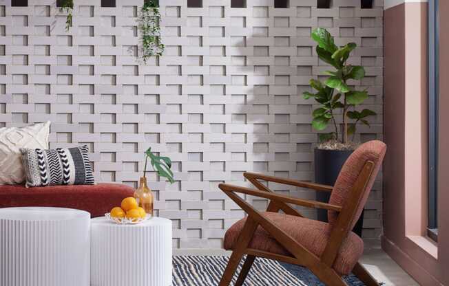 a living room with a chair and a couch and a striped rug