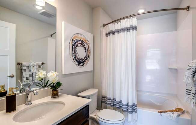 A bathroom with a white sink and a white toilet.
