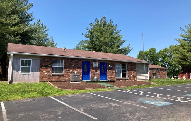 a brick building with blue doors in a parking lot