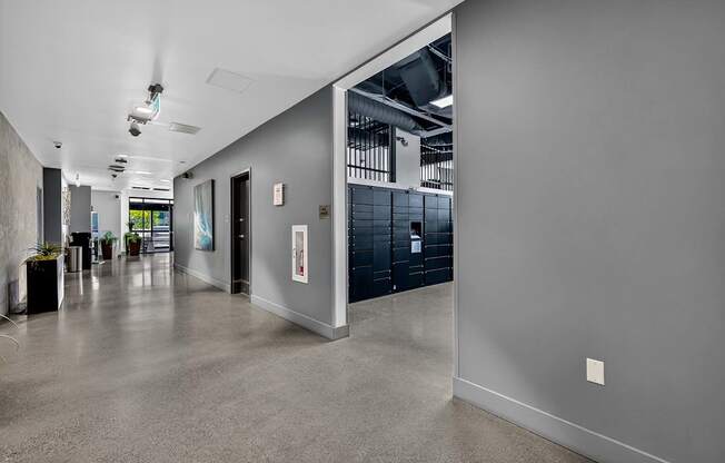 A long hallway with a grey floor and walls.