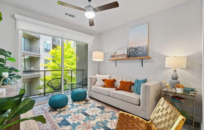 A living room with a couch, a chair, a rug, and a painting on the wall.