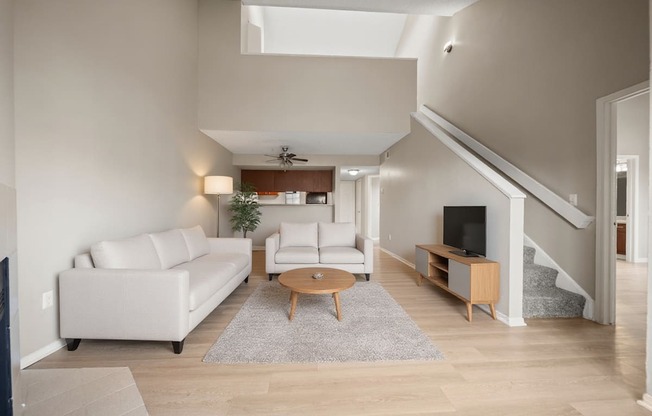 A living room with a white couch and a wooden coffee table.